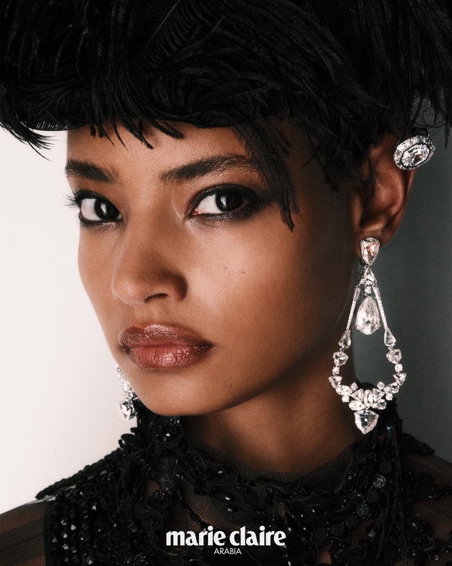 اقراط أذن من Swarovski فستان من Maison Margiela قبعة من Benjamin Paul