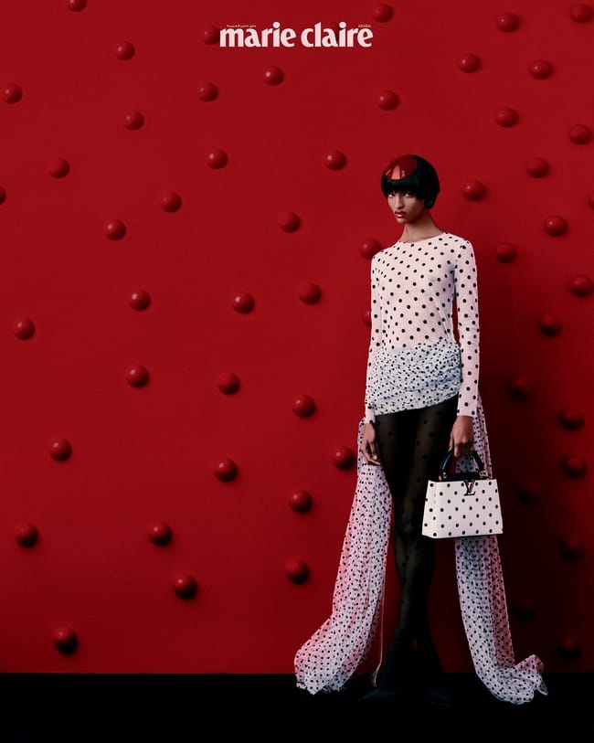 بلوزة من Fernanda Yamamoto وحقيبة من Louis Vuitton وأقراط من Lool وجوارب من Calzedonia مع جزمة من Dolce&Gabbana
