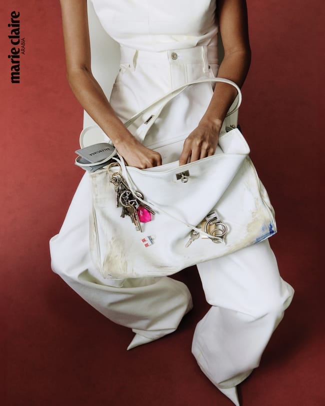 بلوزة ضيّقة من الجلد، من Sportmax سروال جينز بخصر عالٍ من القطن، من Loewe حقيبة من الجلد، من Balenciaga حذاء من الجلد، من Prada