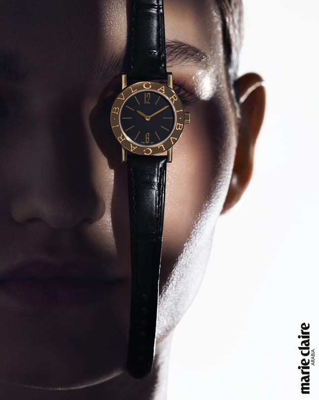 ساعة Bvlgari Bvlgari بإطار من الذهب الأصفر وقرص منقوش عليه شعار الدار المزدوج وميناء من الأوبالين الأسود وسوار من جلد التمساح الأسود.